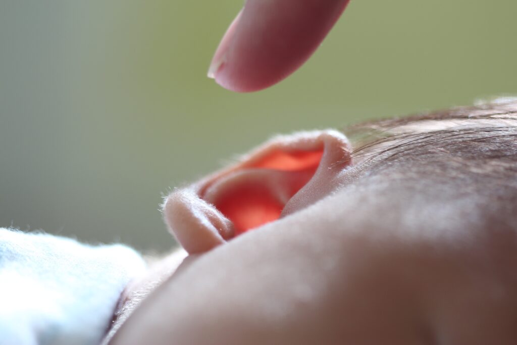 Finger berührt fast das Ohr eines Schafenden Babys. Mit hochsensiblen Kindern gut umgehen und Akzeptanz üben
