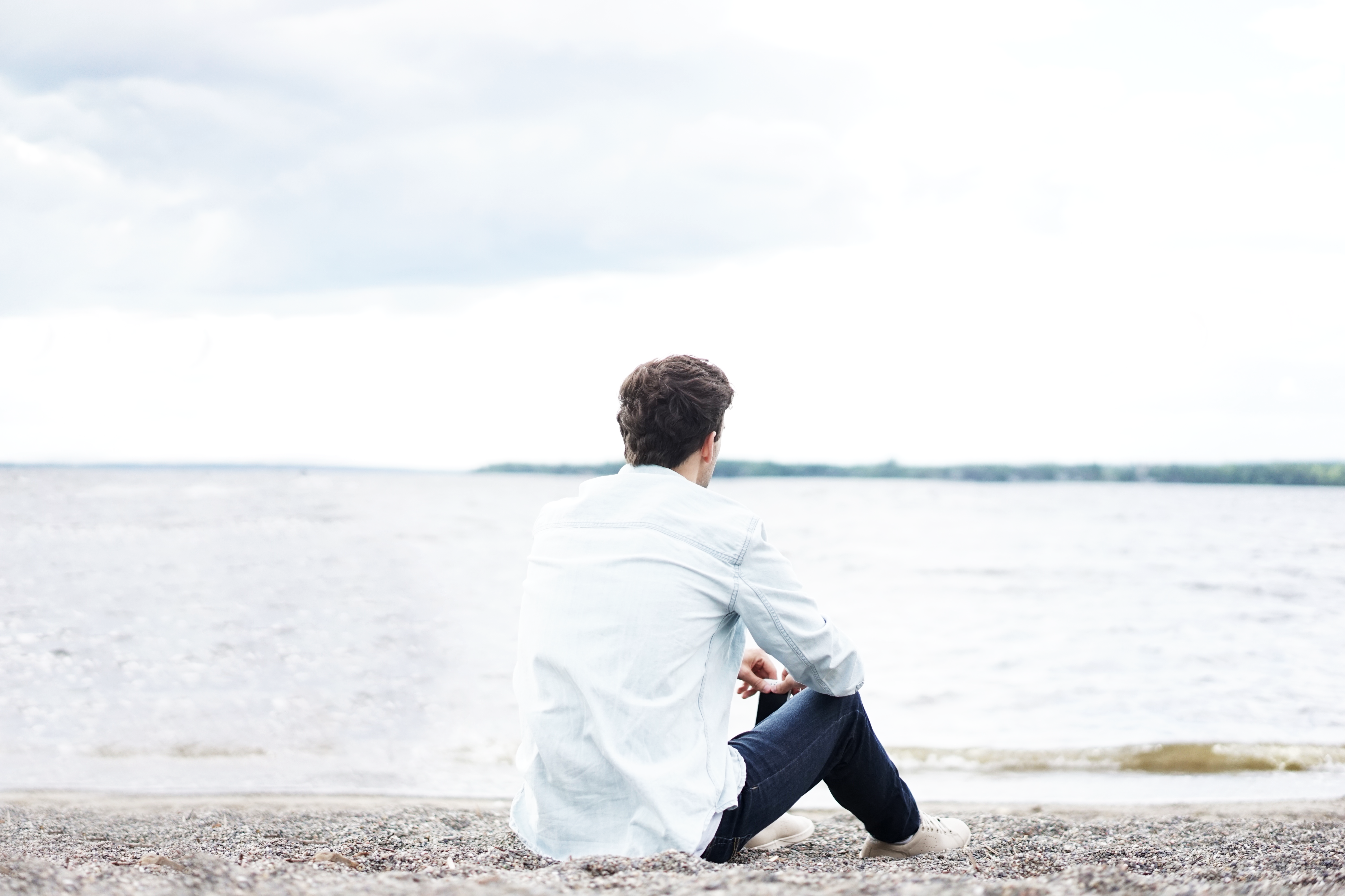 Mann sitzt allein am Strand. Allein zur Paartherapie? Geht das?