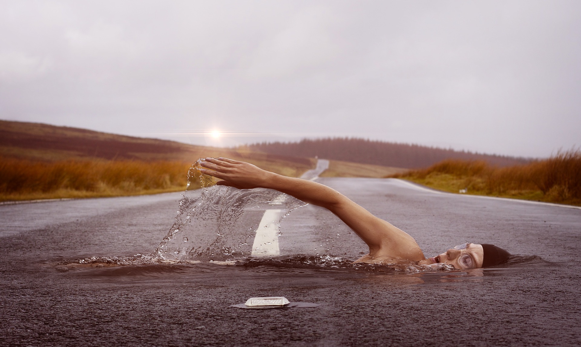 Fotomontage eines Schwimmers, der scheinbar durch eine Straße schwimmt. - Waldbaden ist deutlich entspannter. Aber gerade hochsensible Kinder sind von einem tiefen erleben geprägt und tauchen manchmal tiefer ein, als es ihnen gut tut.