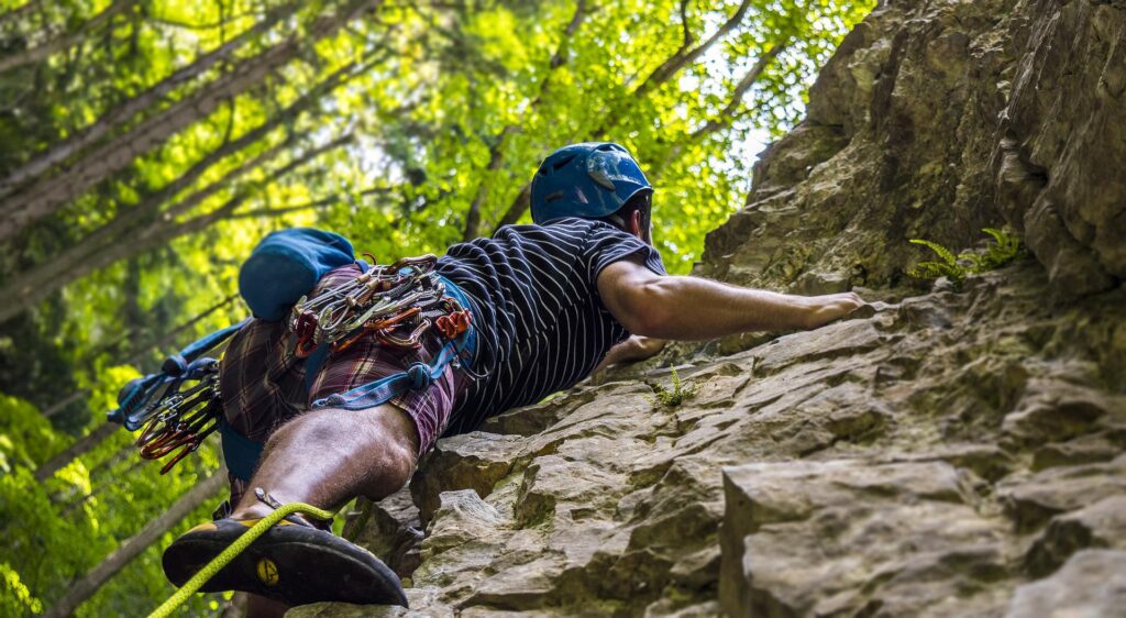 eine Frau klettert auf einen Berg und sucht nach Wegen. Eine Lösungsorientierung lässt Wege finden.