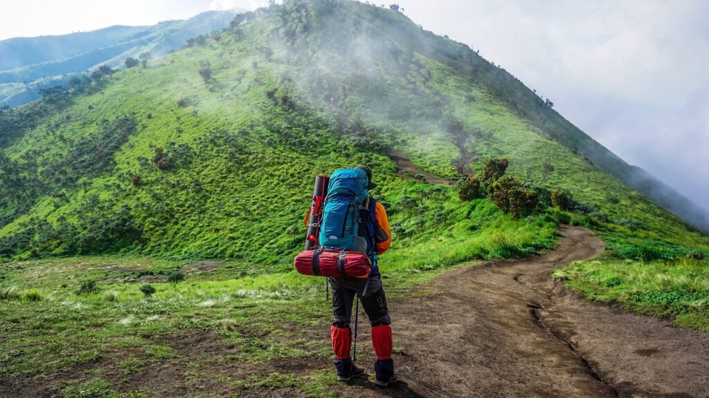 Ein Wanderer hat einen langen und steilen Weg vor sich. Mit Zukunftsorientierung geht er den Weg zuversichtlich.